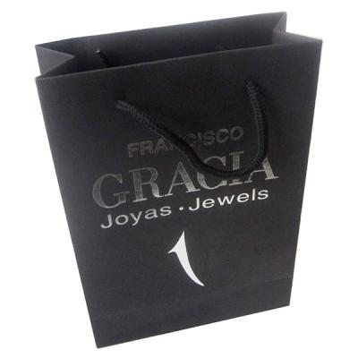 China Recyclable Black Color Bag Slogan Carry On Packaging Paper Bag With Silver Foil Stamping for sale