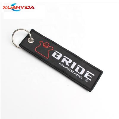 China Metal Embroidered Logo Black Cloth Racing Bride Key Chains for sale