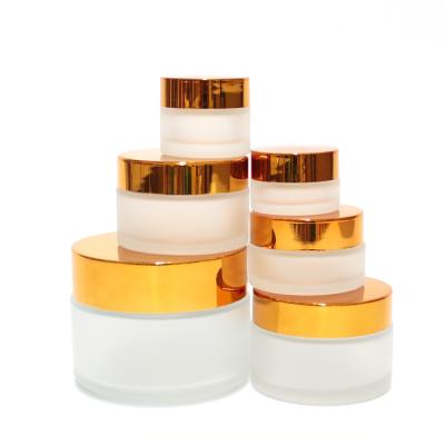 China Empty Glass Round Shape Frosted White Colored Body Butter Jars With Golden Lid for sale