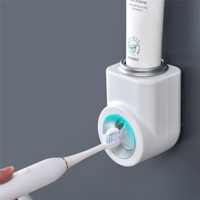 China Modern Dustproof With Suction Super Sticky Pad Wall Mounted Toothbrush Holder And Automatic Toothpaste Dispenser for sale