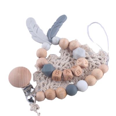 China Eco-Friendly Infant Teething Rattle Chain Silicone Soother Beech Wood Soothing Teether Preventing Lost Pacifier Chain with Bells for sale