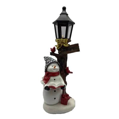 China Europe Christmas Handmade Snowman Reading Book Under Solar Lamps Ornament Open Outdoor Snowman Statue for sale