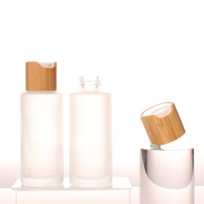 China Personal Packaging 50ml Round Shape Frost Dropper Serum Glass Disc Bottle Empty Glass Top Cap Skin Care Bamboo Top Cap for sale