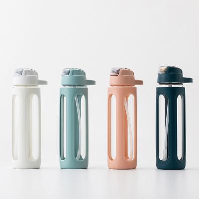 China Sustainable Portable Insulated Glass Water Bottle With Cup Above Straws Spout Creative Flip for sale