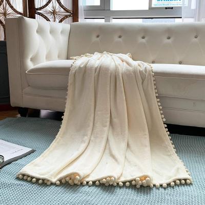 China Anti-static High Quality Solid Microfiber Fleece Flannel Luxury Throw Ball Tassel Blanket With Pompom Tassel for sale