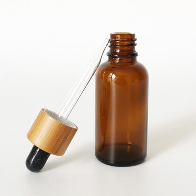 China Cosmetic Glass Dropper Bottles 30ml Essential Oil Glass Brown Amber Bottle With Bamboo Cap for sale