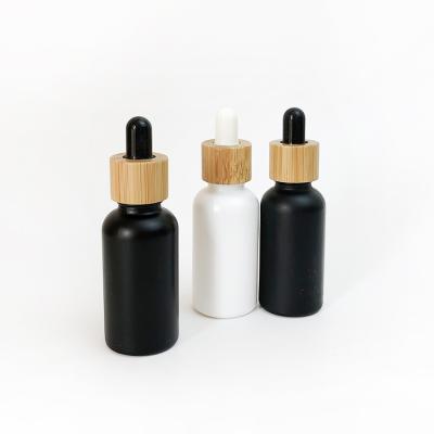 China 1OZ Cosmetic Matte Black White Round Glass Bottle With Bamboo Cap Essential Oil Dropper Cosmetic Bottle 30ML IN STOCK for sale