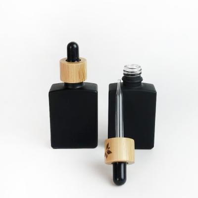 China 30ml 50ml Glass Bottle Rectangle Cosmetic Empty Frosted Black Dropper Bottle Glass for sale