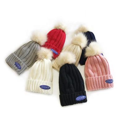 China COMMON Wholesale Custom Winter Hat Plain Pom Pom Knitted Beanies With Woven Blank Label for sale