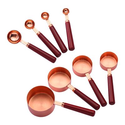 China Viable Measuring Cups and Spoons Set Wooden Handle Rose Gold Measuring Tools Stainless Steel Set of 8 Tablespoon Stackable Cup Teaspoon for sale