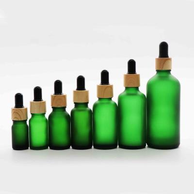 China Round 5ml 10ml 15ml 20ml 30ml 50ml 100ml Green Round Wooden Grain Packaging Glass Cosmetic Empty Cosmetic Bottles Bottles for sale