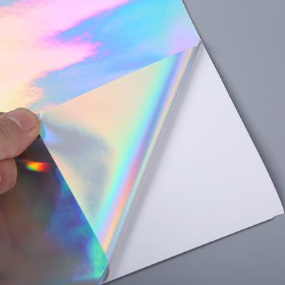 China Waterproof Ready To Ship Wholesale 250grams Rainbow Adhesive Silver Rigid Wrap Laser Holographic Paper for sale