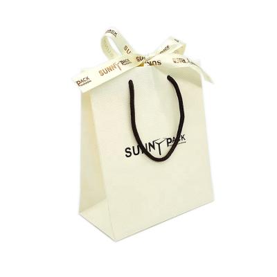 China Durable Custom Logo Luxury Beige Mini Gift Bag Small Jewelry Paper Bag With Ribbon Tie Bow for sale