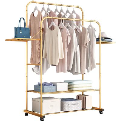 China Modern simple stretch bedroom clothes rack outside portable clothes rack luxury gold standing coat rack for sale