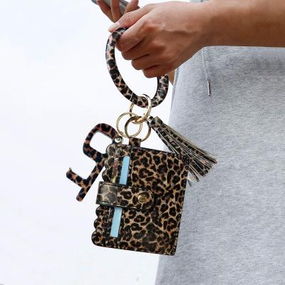 China 2021 fashion large leopard portable leather wristband leather wristband PU wristlet lipstick and wallet sleeve door opener tassel touchless card holder purse for sale