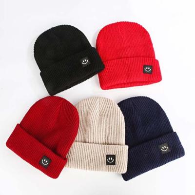 China COMMON Wholesale Custom Cuffed Winter Toque Unisex Beanies Knitted Hat With Leather Patch Label for sale