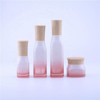 China New Personal Care Cosmetics Subbottling, Red Wooden Cherry Blossom Grain Cover Perfume and Cream Press Packaging Glass Bottle with Sprayer Pump for sale