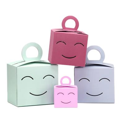 China Disposable Colorful Cute Smile Printing Gift Box Pink Color Art Paper Packaging With Handle for sale