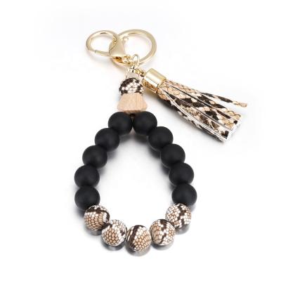 China PU Environmental Friendly Wooden Tassel Beads Key Chain Wristband Silicone Keychain Anti-lost Wristband for sale