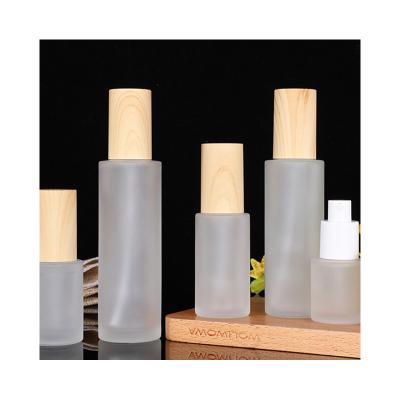 China Personal Care Customized Frosted Lotion Serum glass bottle with bamboo lid bamboo shampoo bottles glass bottles for sale