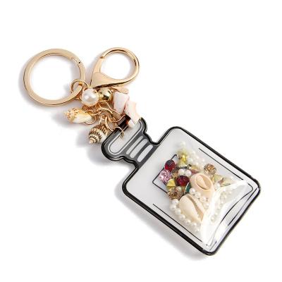 China Creative Fashion Crystal Conch Shell Key Ring Women's Hot Selling Perfume Bottle Shape Key Chain Bag Pendant Gifts for sale