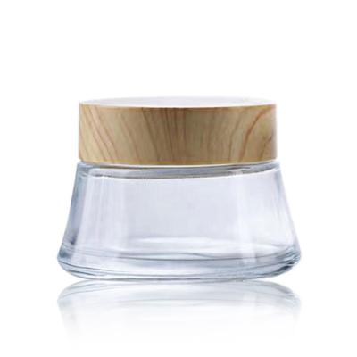 China Factory direct sale 100g stain cosmetic lotion cream jar wide mouth glass bottle cream bottle with plastic wood grain cover for sale