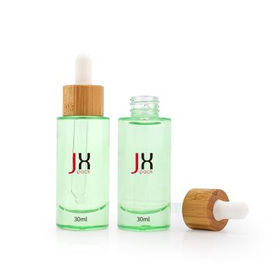 China 30ml Customized Flat Shoulder Cosmetic Clear Green Glass Dropper Bottle For Essential Oil Perfume Cosmetic Packaging for sale