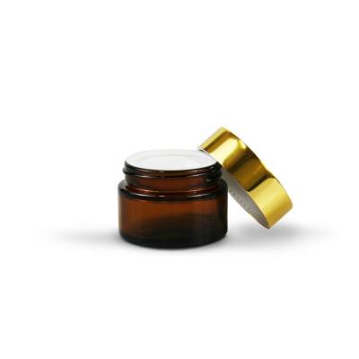 China 2 Ounce Cosmetic Amber Glass Makeup Jar Gold Packaging Cream Foundation Lid for sale