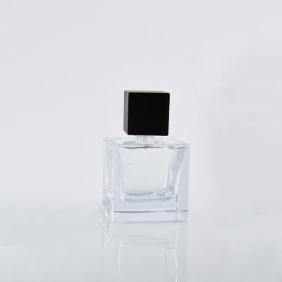 China Cosmetic Hot Sale 50ml Square Empty Transparent Glass Perfume Bottle With Black Cap for sale