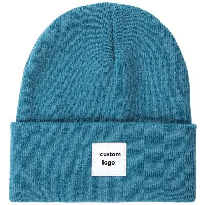 China Common Lake Blue Skullcap Custom 100% Acrylic Cuff Knit Skullcap With Woven Patch for sale