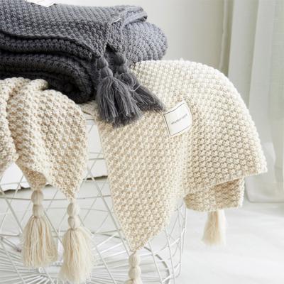 China Solid Color Anti-static Textured Lightweight Comfortable Tassels Design Office Acrylic Knitted Blanket With Pom Pom for sale