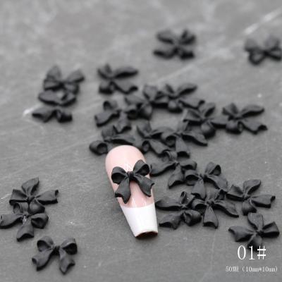 China Resin Classic black and white nail bow, brand new minimalist resin nail ornament, three-dimensional ribbon for sale