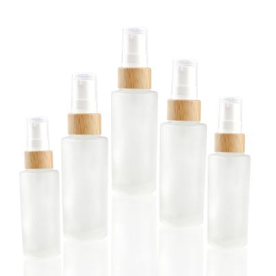 China Foam Wash Glass Cosmetic Bottle With Foam Pump For Lotion Cream Bamboo Lid Bottle 50ml 100ml 120ml 150ml for sale