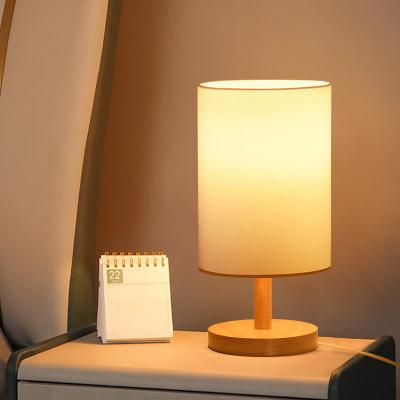 China Nordic Simple Canvas Fabric Shade Cylinder Table Lamp Minimalist OEM Bedside Mini Desk Lamp Wood Base for sale