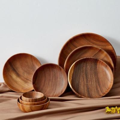 China Sustainable Wholesale Customized Handmade Dessert Solid Black Wooden Dishes Acacia Wood Round Dinner Charger Plates for sale