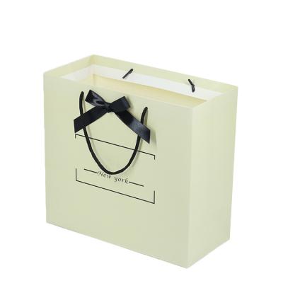 China Recyclable White Fancy Paper Jewelry Gold Foil Logo Gift Paper Bag With Custom Cloth Handle for sale