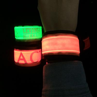 China Stock Manufacturer Cheap Custom Color Party/Night Text Logo Rubber LED Slap Band Silicone Wristband Slap Wristband for sale