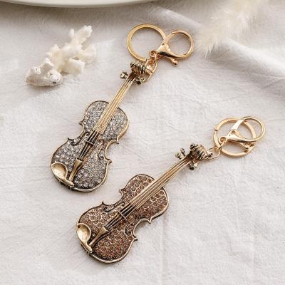 China 2022 Hot Selling Fashion Guitar Crystal Rhinestone Keychain Bag Buckle Handbag Pendant For Car Key Ring Korean Guitar Shaped Key Chain for sale