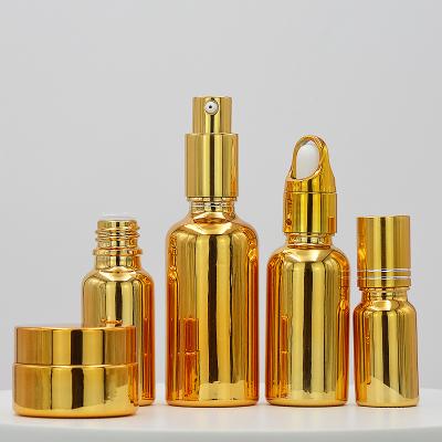 China 5ml 10ml 15ml 20ml 30ml 50ml 100ml Custom Gold Coating Cosmetic Glass Empty UV Liquor Bottle Dropper Bottles Essential Oil for sale