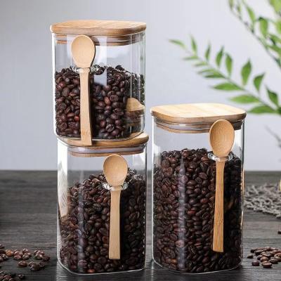 China Sustainable Wholesale Borosilicate glass airtight tank square storage coffee jar glass  bottle container with wooden spoon and bamboo lid for sale