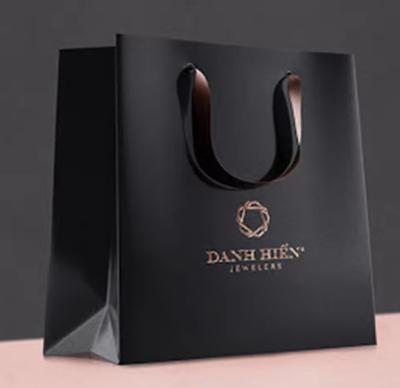 China Luxury Black Paper Apparel Packaging Gift Shopping Bag Customized Branded Logo for sale