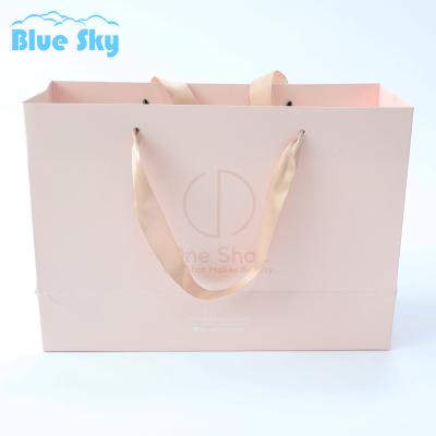 China Recycled materials China beauty product reusable gift white paper manufacturer customized colthing bag with your own logo for sale