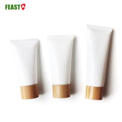 China 100g Cosmetic Empty Cream Tube For Body Care Bright Black Soft Tube Plastic Cosmetic Packaging With Bamboo Lid for sale