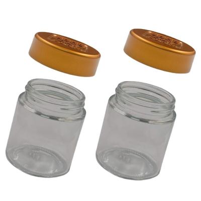 China Factory direct wholesale durable customized 2oz clear glass jar with gold CR lid for cosmetic paste storage for sale