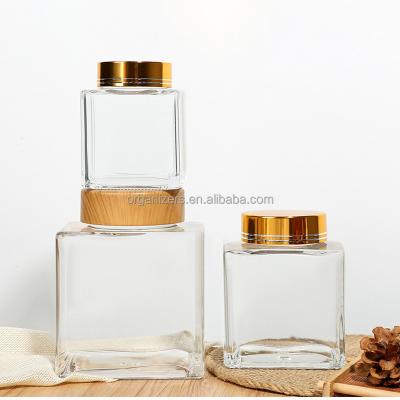 China Stocked Large mouth flat square honey chili sauce jam glass bottle sealed food glass jar with wood lid for sale