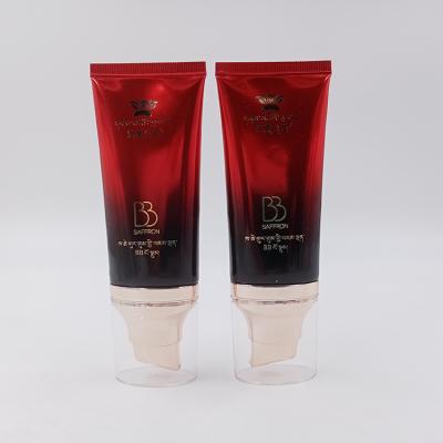 China Cosmetic Manufactures PE 50ml 100ml Red Gradient Plastic Cosmetic Lotion Tube Empty Oval BB Cream Tube With Gold Flat Airless Pump for sale