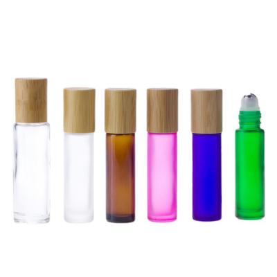 China 10ml 15ml Cosmetic Essential Oil Clear Refillable Glass Roll On Bottle With Steel Roller Ball And Bamboo Lid for sale