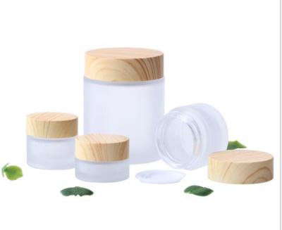 China 100g Cosmetic Wooden Grain Cover Frosted Around Glass Cosmetic Jars Jar Cream Bottles for sale