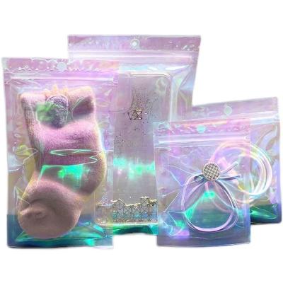 China Low MOQ Moisture Proof Stock Candy Bags Three Side Seal Bag Mylar Holographic Ziplock Packaging Clear Plastic Jewelry Bags for sale