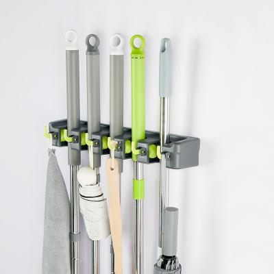 China Sustainable Cleaning Tool 5 Slots 6 Hooks Spring Loaded Slots Broom Plastic Holder for sale